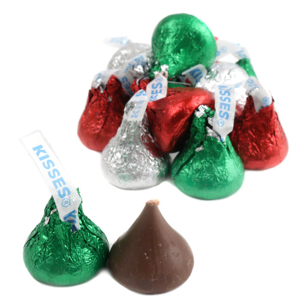 Many assorted Christmas Hershey Kisses, shiny red, green, and silver foil-wrapped chocolates, a festive holiday treat.