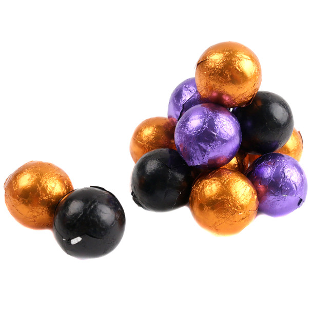 Many Halloween chocolate balls, solid milk chocolate, individually foil-wrapped in festive orange, black, and purple designs.