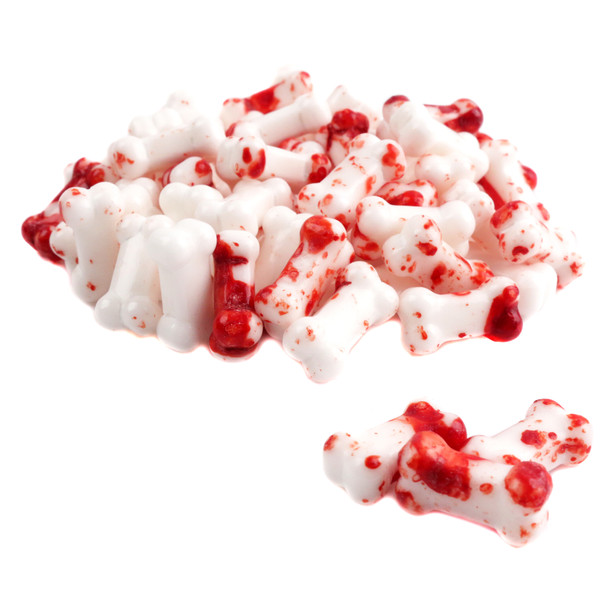 White bone-shaped pressed candy with red blood splatters, approx 350 per pound. Ghoulish Halloween sweets decoration.