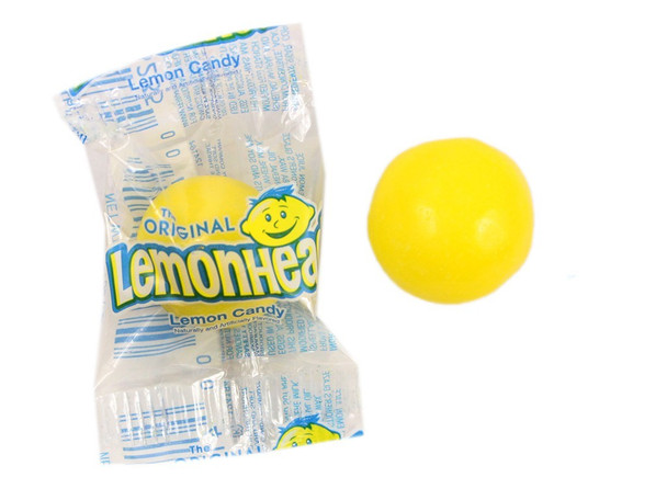 Vibrant yellow, individually wrapped Lemonheads candy, 27lb bulk. Round, sour lemon hard candies.