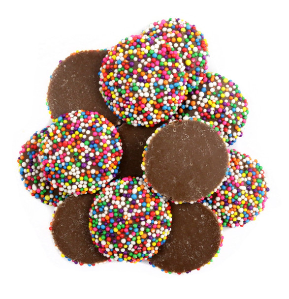 Large pile of milk chocolate rainbow nonpareils, bright rainbow sprinkles covering one side of rich chocolate candy.