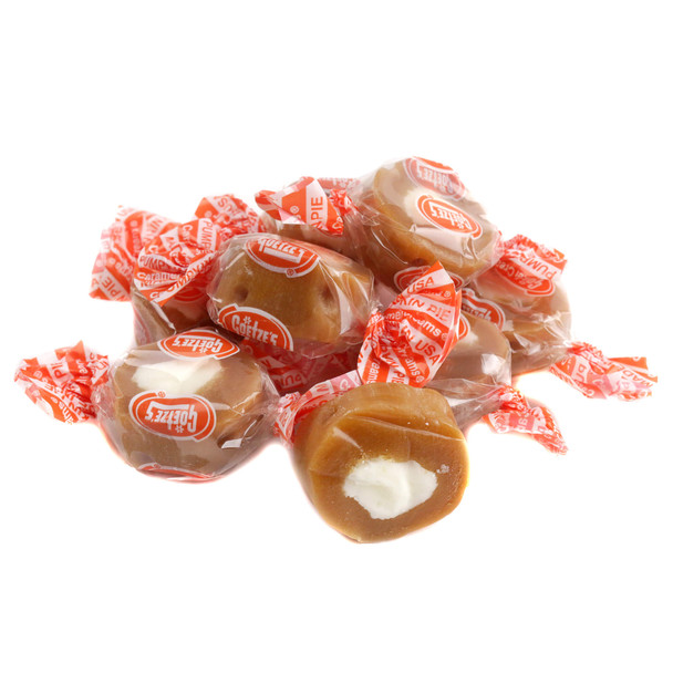 A close-up view of unwrapped Goetze's Pumpkin Pie Caramel Creams showing the chewy golden caramel ring and spiced cream cente