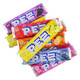 Multiple individual Pez candy refill rolls showing colorful, classic foil packaging and various flavor labels.