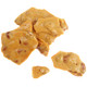 Close-up of glossy golden-brown peanut brittle showing whole roasted peanuts embedded in caramel candy.