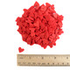 Red heart shaped sprinkles, approximately 1/4 inch, for decorating desserts like cupcakes and cookies.