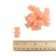 Approximately 130 pale golden, sour Prosecco flavored gummy bears with a chewy texture.