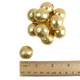 Close-up photo of metallic gold foil covered chocolate balls with a glossy finish.