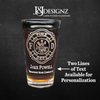 Promotional image for JJDesignz custom laser etched glassware, featuring a personalized firefighter pint glass with Maltese Cross, name and additional next line. Highlighting the availability of two lines for text customization.