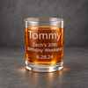 Whiskey glass filled with amber liquid on a charcoal background, showing custom engraving with a name, birthday message, and date.