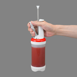 Handheld Portion Pal™ filled with ketchup suspended in the air