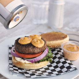 Sauce Gun Bottle with large valve 3-hole dispensing cap dispensing Harissa sauce onto a burger