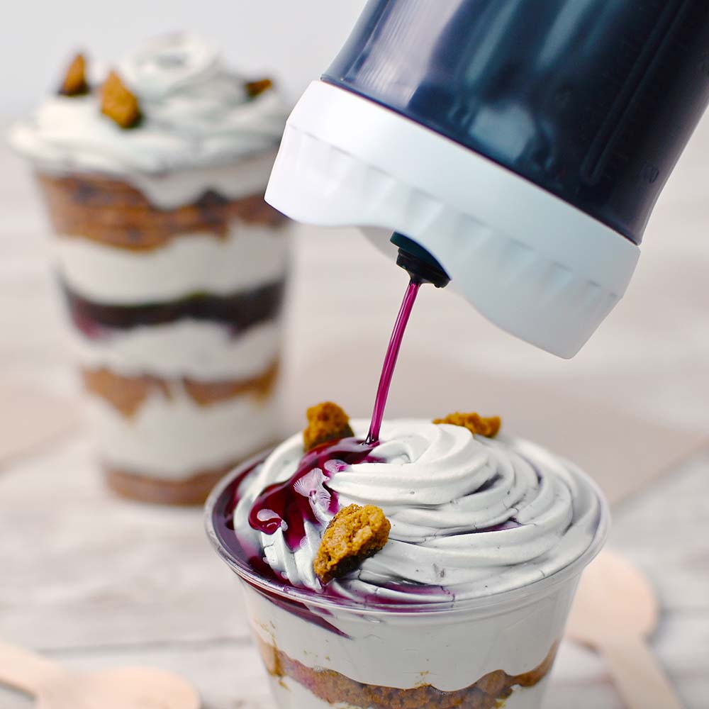 Portion Pal™ dispensing boysenberry syrup onto a soft serve sundae