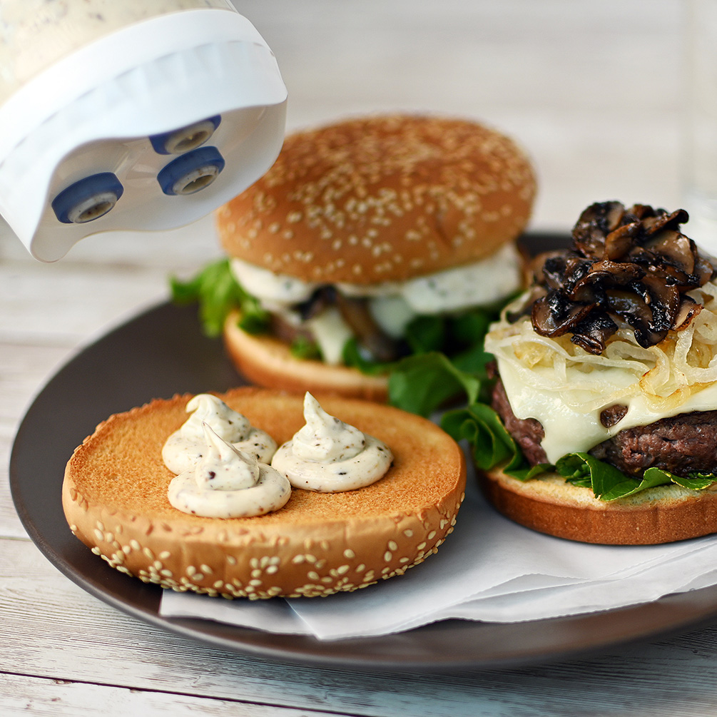 Portion Pal™ dispensing truffle aioli onto a swiss mushroom burger
