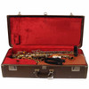 Open brown Buescher hard case with red plush lining, holding the saxophone, neck, mouthpiece, strap, and accessories. card