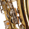 Lower keywork and bell-side detail with pearl touches, orange resonators, and mixed gold and silver-colored hardware. card