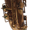 Lower saxophone body with key guards, rods, and worn brass finish. card