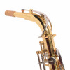 Corked saxophone neck with octave mechanism and light surface marks on the gold lacquer. card
