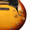 Close-up of the Gibson ES-335 '50s control section showing the four gold top hat knobs, three-way toggle switch, and treble-side f-hole.