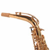 Close-up of the saxophone neck and upper body showing extensive lacquer wear, scratches, and dark discoloration along the curved neck. card