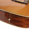 Close-up of the lower side of the used 1992 Washburn D-25S/N acoustic guitar showing the figured wood grain, body binding, and strap button. card