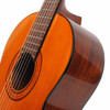 Close angled view of the guitar’s upper body showing the natural top, dark binding, glossy wood side, soundhole, and fingerboard. card