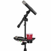 Clamp-on microphone stand accessory tray mounted below a microphone, holding a drink, phone, keys, and guitar picks with integrated cup holder. card