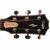 Close-up of the Taylor headstock with "The Den" 35 Years truss rod cover and Taylor logo. card