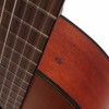 Close-up of the Yamaha CGX122MC-NT neck joint showing a teardrop-shaped finish chip/indentation beside the fingerboard. card