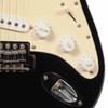 Close-up of Squier Strat controls showing volume and tone knobs, five-way pickup selector, tremolo bridge, and output jack. card