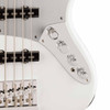 Close-up of Fender Jazz Bass electronics showing dual pickups, silver pickguard, four chrome control knobs, toggle switch, and chrome bridge. card