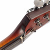 Close-up of the back edge of the headstock showing finish wear, chipping, scratches, and exposed lighter wood along the edge. card