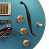 Close-up of the guitar controls, right f-hole, gold knobs, and pickup selector switch. card