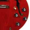 Close-up of the lower front body showing the pickup selector, volume and tone controls, f-hole, output jack, and cherry wood grain. card