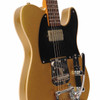 Angled close-up showing the gold finish, cream body binding, black pickguard, pickups, bridge, controls, and Bigsby vibrato. card