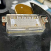 Interior close-up beneath neck humbucker showing pickup baseplate, mounting hardware, wiring, and cavity. card