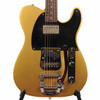 Close-up front view of gold Squier Custom Telecaster with black pickguard, neck humbucker, angled bridge pickup, and Bigsby vibrato. card
