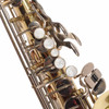 Close-up of lower keywork, pearl touches, and key guards on the saxophone body. card