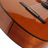 Close-up of the classical guitar bridge and lower body showing the glossy natural top and dark body binding. card