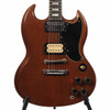 Close-up of walnut SG body with black pickguard, mismatched humbuckers, and chrome hardware. card