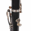 Close-up of clarinet serial number markings and thumb rest with visible hardware tarnish. card