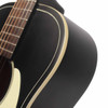 Close-up of upper guitar body showing matte black finish, cream binding, and fingerboard. card