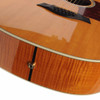 Close-up of natural guitar top, black bridge, and output jack on figured wood sides. card