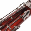 Close-up of bassoon keywork showing scuffs, scratches, and worn finish around the metal mechanisms. card