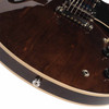 Close-up of dark walnut body grain, chrome stopbar tailpiece, cream binding, and strap button. card