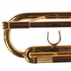 Close-up of trumpet leadpipe, tuning slide, and finger hook with light scratches on lacquer finish. card