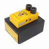 Angled view of MXR Distortion+ pedal on its box, showing input jack, power connection, and yellow enclosure. card