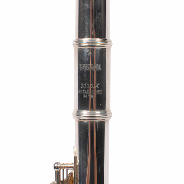 Close-up of the Yamaha YFL-211DX model engraving and body joint markings. card