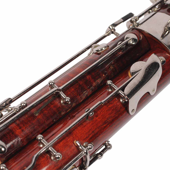 Close-up of bassoon keywork showing scuffs, scratches, and worn finish around the metal mechanisms. card