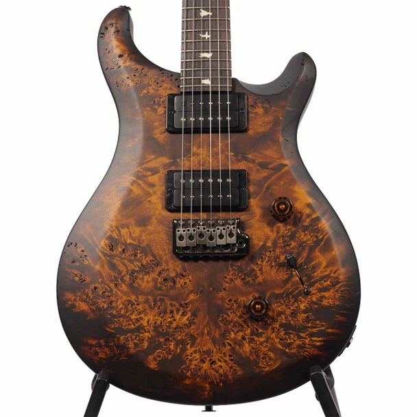Front body close-up of PRS SE Custom 24 with amber-brown burled wood top, black humbuckers, and tremolo bridge. card