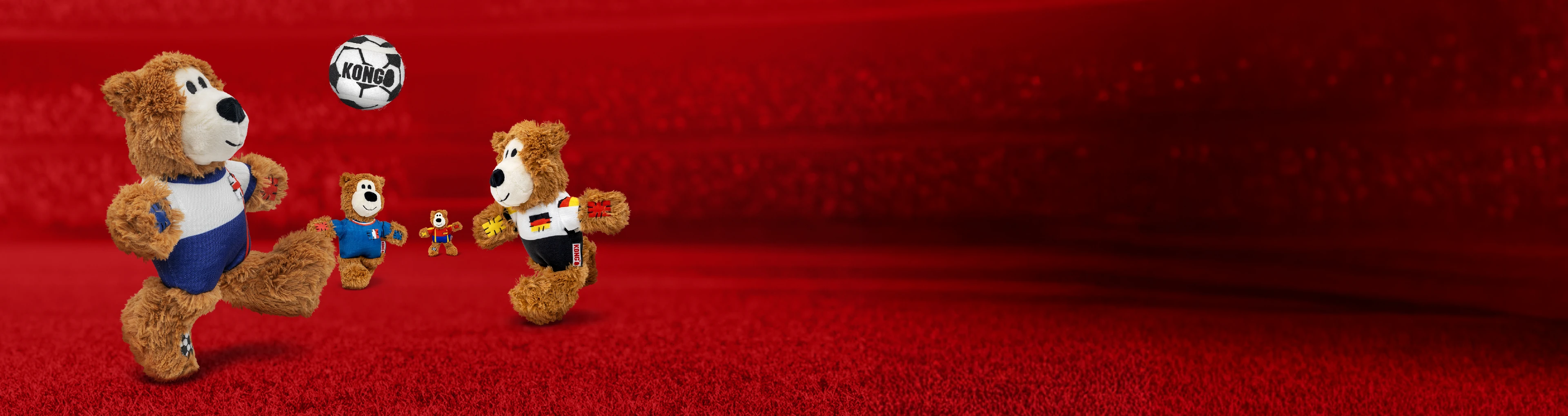 Bear stuffed animals playing soccer with different country jerseys on. The background is a red blurred out soccer field.